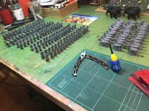 Gripping Beast 28mm plastic Arabs on the Editor's table getting the mass production treatment. In the background, a clutch of Aventine Miniatures resin elephants.