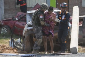 Military medics and soldiers tend an injured civilian