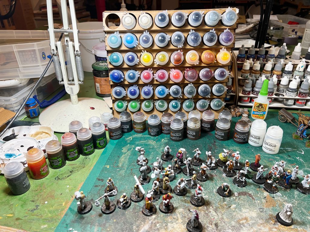 painting table with contrast paints and miniatures